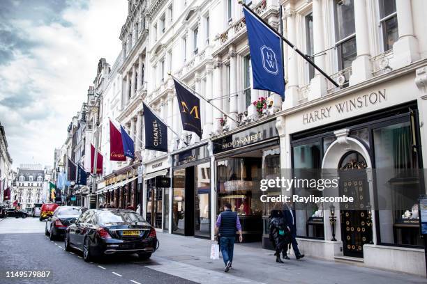 las personas que caminan por tiendas de joyería exclusivas de alta gama como chanel, cartier en new bond, londres, inglaterra - area designer label fotografías e imágenes de stock