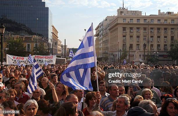 Demonstrator waves the Greek flag as protestors gather for a protest rally organised in front of Athens University on May 31, 2011 in Athens, Greece....
