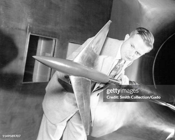 Aviation pioneer Richard Whitcomb holds an Area Ruled Aircraft test model in the Langley 8-Ft Transonic Wind Tunnel, Langley Research Center,...