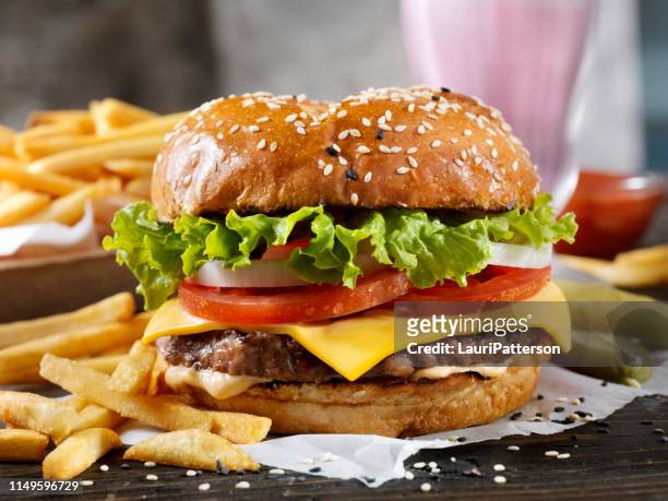 klassischer cheeseburger auf einem brioche bun mit fries und einem milkshake - cheeseburger and fries stock-fotos und bilder