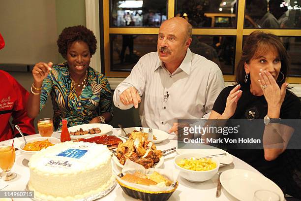 Tren'ness Woods Black, Dr. Phil McGraw, and Robin McGraw enjoy dinner at Sylvia's Soul Food restaurant during the taping of Dr. Phil Hits The Streets...