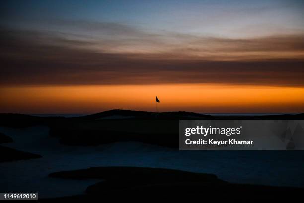 General view of the pinflag on the 17th hole silhouetted against the sunset during previews for the 2019 U.S. Open at Pebble Beach Golf Links on...