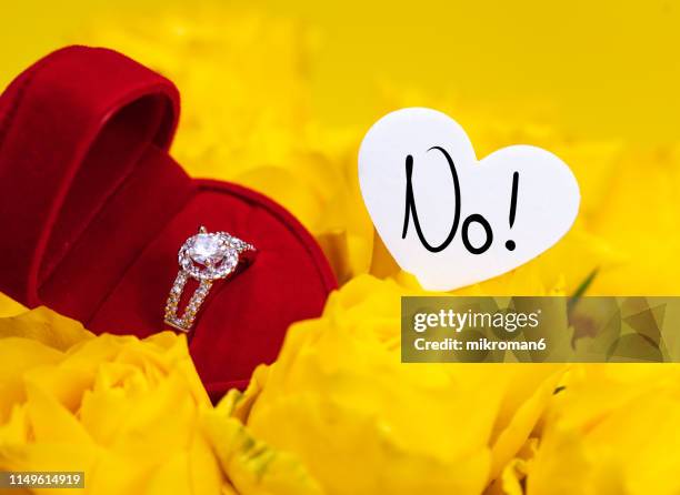 yellow roses with engagement ring and a heart with no - unwanted present stock pictures, royalty-free photos & images