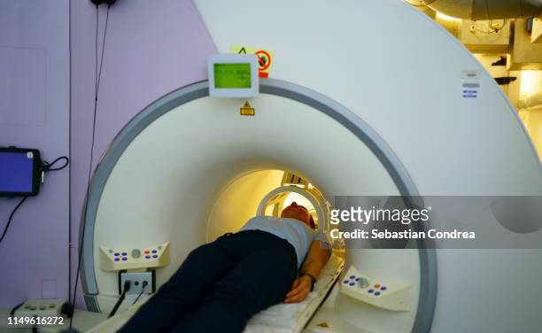 woman about to receive an mri scan of her head. - mri machine stockfoto's en -beelden