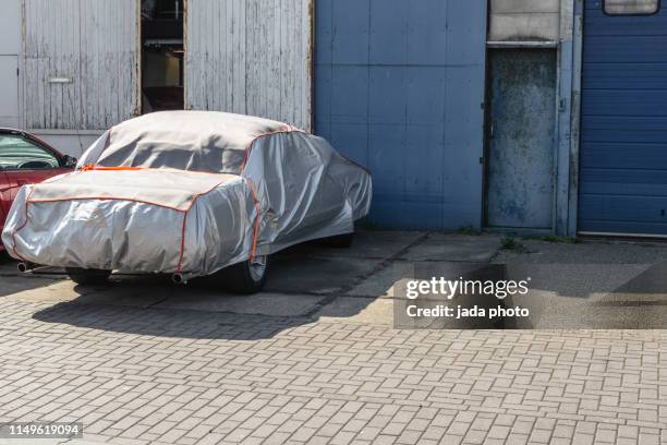 car packed with a gray colored cover - car cover garage stock pictures, royalty-free photos & images