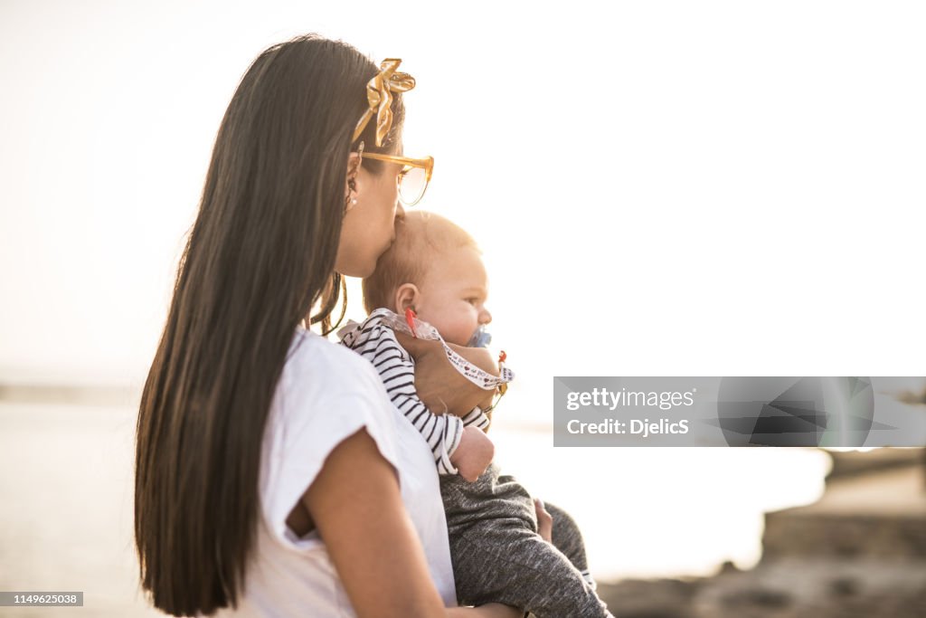 Young mom kissing her beloved baby.
