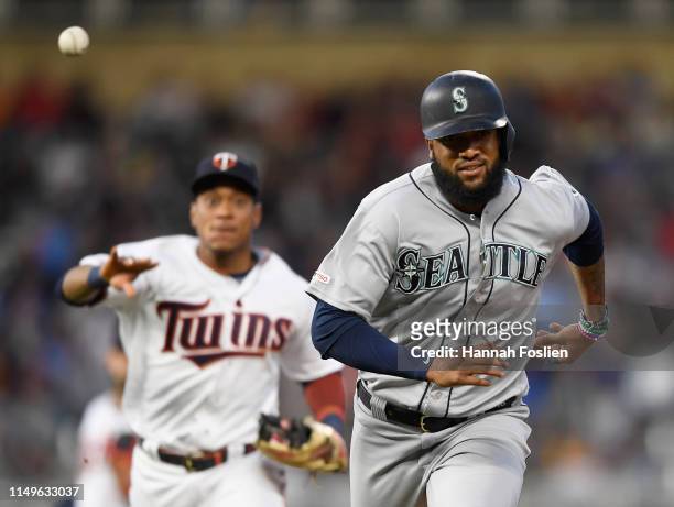Jorge Polanco of the Minnesota Twins passes the ball over Domingo Santana of the Seattle Mariners after Santana was caught off first base during the...