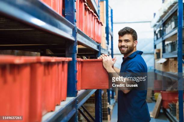 porträt lächelnder arbeiter arbeitet im lager - warehouse worker stock-fotos und bilder