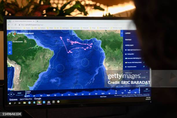 Lacey Malarky, an Oceana campaign manager on illegal fishing and transparency, monitors the GPS position of a fishing boat in the Atlantic ocean from...