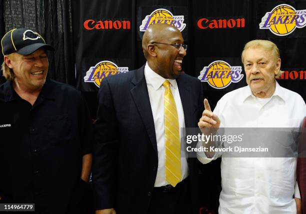 Mike Brown, the new head coach for the Los Angeles Lakers, looks at team owner Jerry Buss speaks while Jim Buss, vice president of player personnel,...