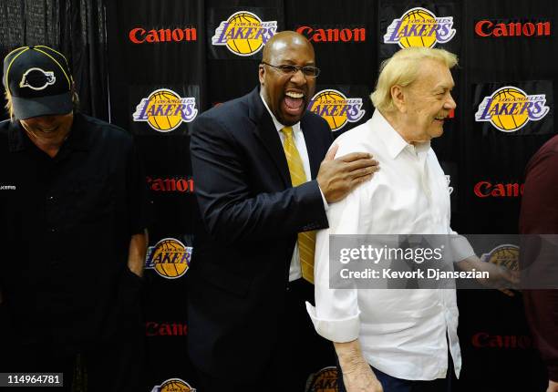 Mike Brown, the new head coach for the Los Angeles Lakers, laughs with team owner Jerry Buss and Jim Buss, vice president of player personnel, after...