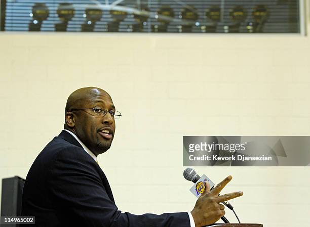 With the Lakers World Championship trophies seen in the window above, Mike Brown, the new head coach for the Los Angeles Lakers, gives a speach...