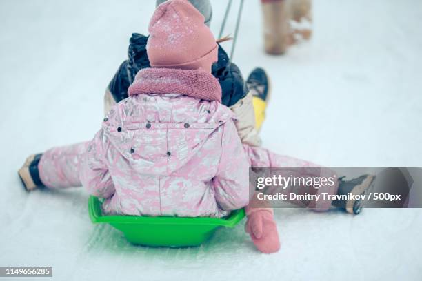 adorable little happy girls sledding in winter snowy day - european best pictures of the day december 8 2014 stock-fotos und bilder