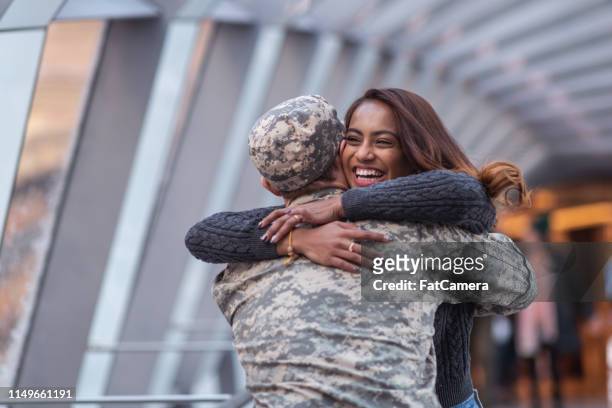 vrouw knuffelen haar partner na thuiskomst van de dienst - married stockfoto's en -beelden