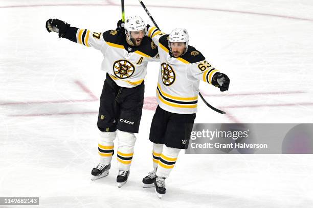 Patrice Bergeron of the Boston Bruins celebrates with Brad Marchand after scoring on Curtis McElhinney of the Carolina Hurricanes during the second...