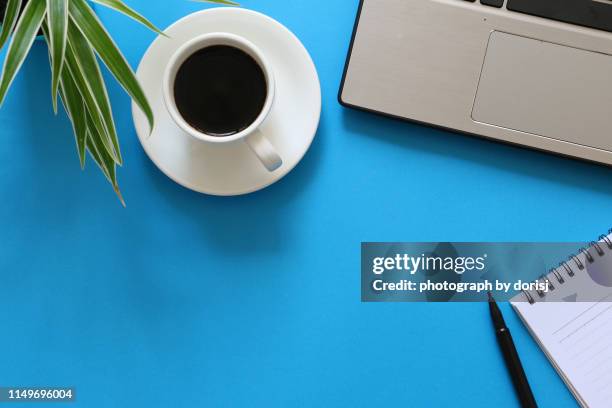 top view of laptop, coffee, notebook, pen and green plant - office work flat lay stockfoto's en -beelden