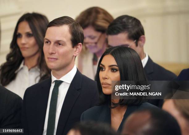 Kim Kardashian and Jared Kushner listen as US President Donald Trump speaks about second chance hiring and criminal justice reform in the East Room...