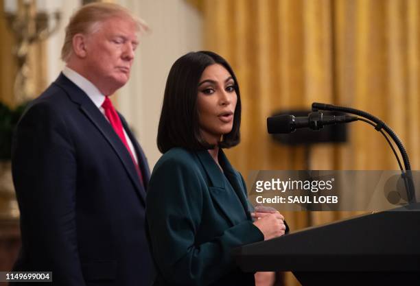 Kim Kardashian speaks alongside US President Donald Trump during a second chance hiring and criminal justice reform event in the East Room of the...