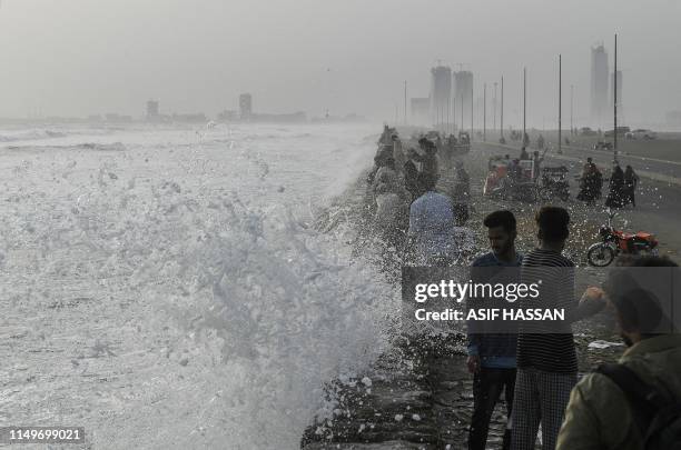 People gather on sea view during high tide of the Arabian Sea in Karachi on June 13, 2019. The tropical cyclone Vayu formed in Arabian Sea has...