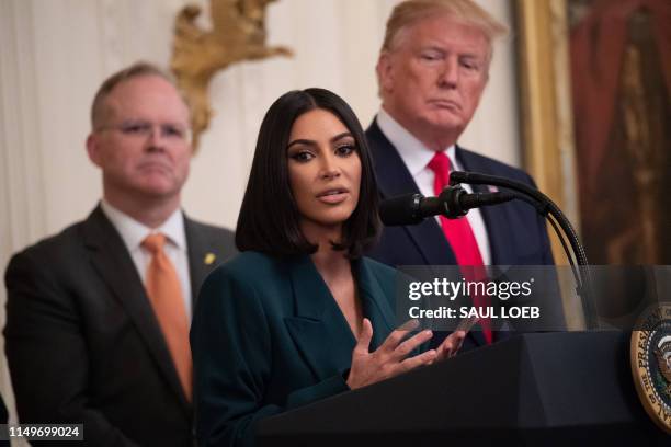 Kim Kardashian speaks alongside US President Donald Trump during a second chance hiring and criminal justice reform event in the East Room of the...