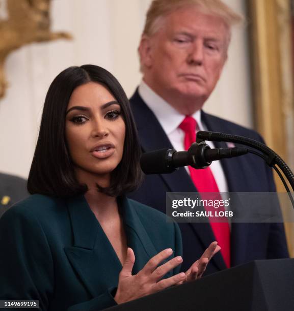 Kim Kardashian speaks alongside US President Donald Trump during a second chance hiring and criminal justice reform event in the East Room of the...