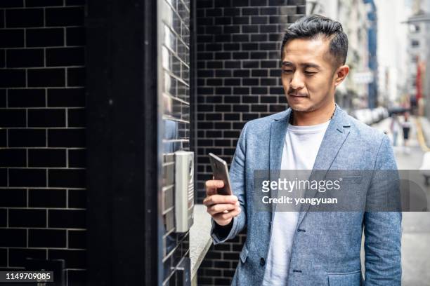 中國男子帶著智慧手機進入家中 - door bell 個照片及圖片檔