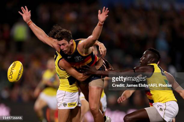 Daniel Rioli of the Tigers tackles Kyle Hartigan of the Crows during the 2019 AFL round 13 match between the Adelaide Crows and the Richmond Tigers...