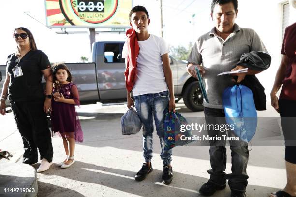 Guatemalan asylum seekers, a father and son , hold their belongings as they prepare to board a bus to meet their sponsors in Las Vegas, after leaving...