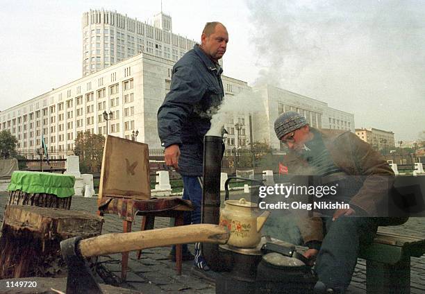 Protesting Russian miners demanding back wages, who have picketed outside the government building for months, boil water outside their makeshift tent...