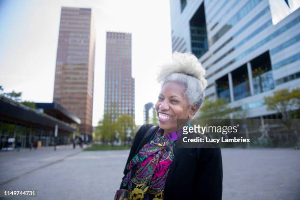 senior business woman cracking up outside her office - amsterdam business stock pictures, royalty-free photos & images