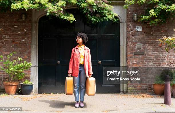 a young woman holding suitcases. - woman leaving fotografías e imágenes de stock