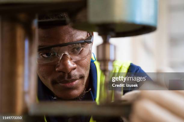 jonge stagiair met juk machine in de fabriek - metaalbewerking stockfoto's en -beelden