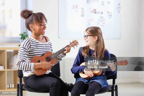 multi-ethnic teacher and student playing ukulele - ukelele stock pictures, royalty-free photos & images