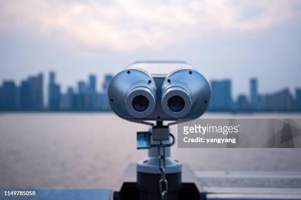 a telescopic view of a distant skyline with a telescope at the city's observatory - periscope stock pictures, royalty-free photos & images