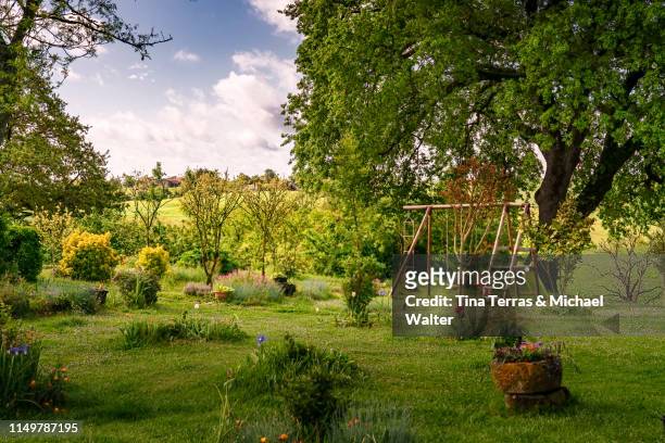 beautiful garden with flowers, lawn and children's toys in france. - garden stock pictures, royalty-free photos & images