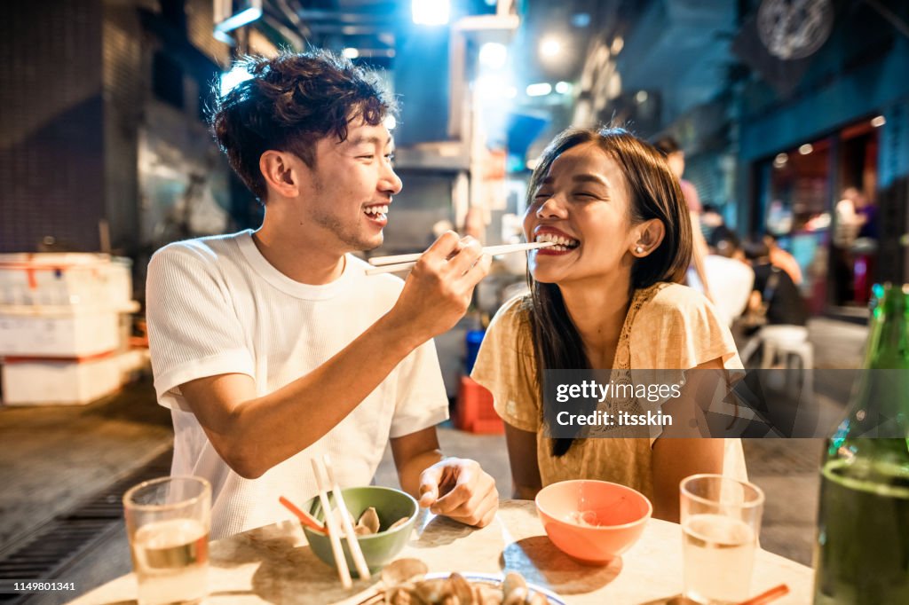 香港のストリートフードを楽しむアジアのカップル