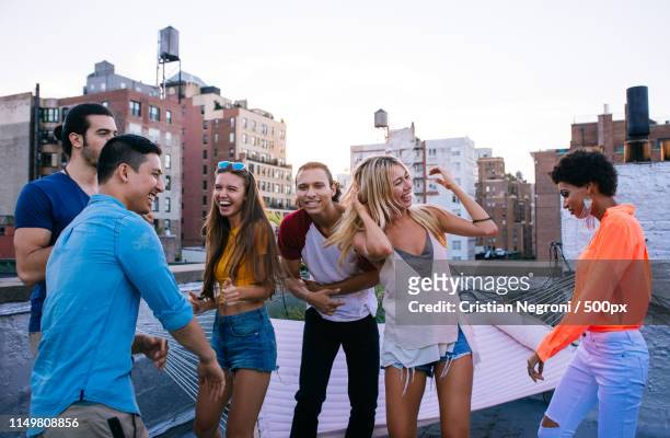 group of friends spending time together on a rooftop in new york - women of penthouse stock pictures, royalty-free photos & images