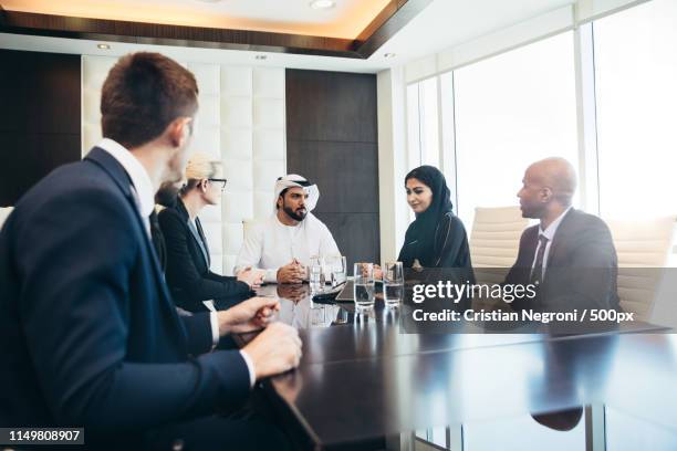 mixed business team making agreements on future business plans - qatar business stock pictures, royalty-free photos & images