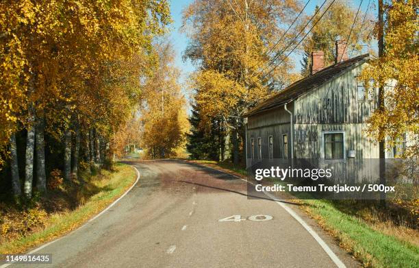 sunny road and a house fall colors in the autumn in finland - teemu tretjakov stock pictures, royalty-free photos & images