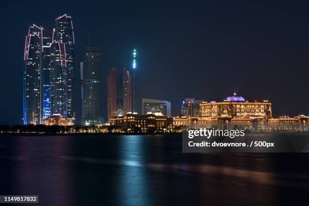 abu dhabi buildings skyline from the sea at night - abu dhabi skyline night stock pictures, royalty-free photos & images