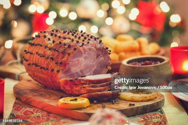glazed holiday ham in front of a christmas tree - honey ham stock pictures, royalty-free photos & images