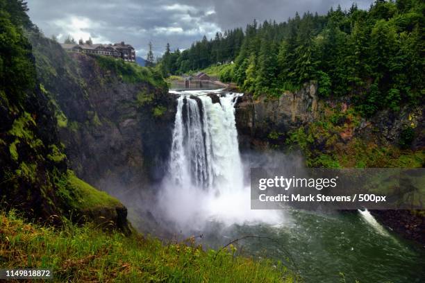 a grassy meadow to complete a setting of snoqualmie falls - nördliches kaskadengebirge stock-fotos und bilder