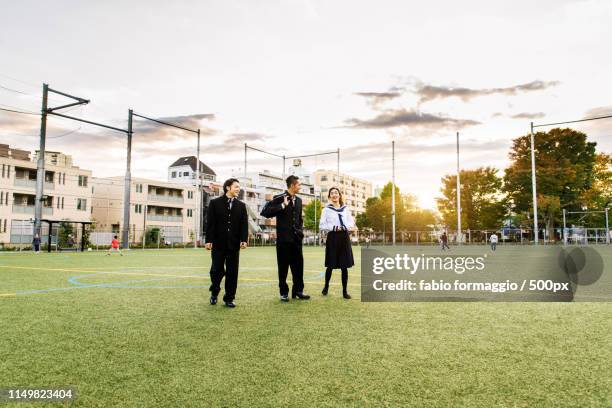 japanese students meeting outdoors - school ground student walking stock-fotos und bilder