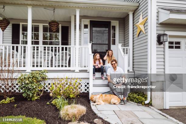 gelukkige familie zitten voor thuis - family in front of house stockfoto's en -beelden