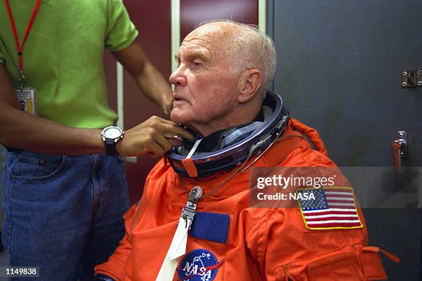 Sen. John H. Glenn Jr. , is assisted by suit experts Jean Alexander and Carlous Gillis prior to a training session at the Johnson Space Center . The...