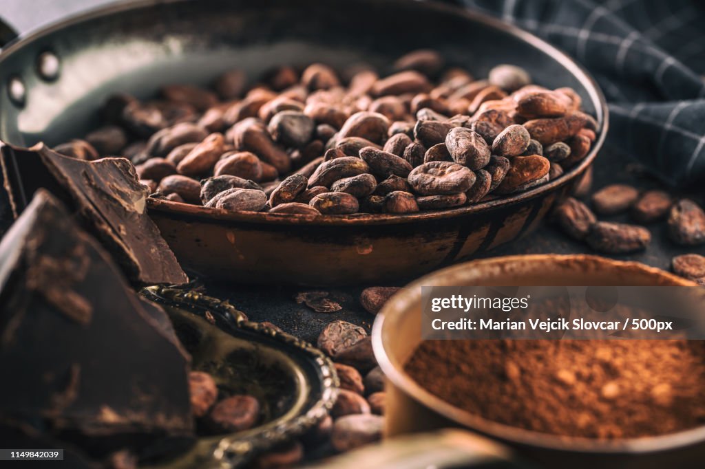 Dark Chokolate Cocoa Beans And Powder On Concrete Table