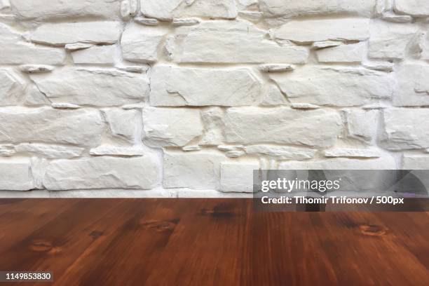 old brown oak wooden table on the blurry white wash wall background, wood table - table brick wall wood stock-fotos und bilder