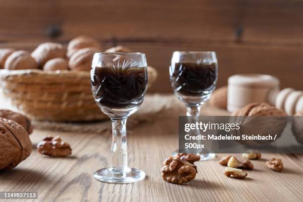 two glasses of homemade nut liqueur with walnuts - liqueur 個照片及圖片檔