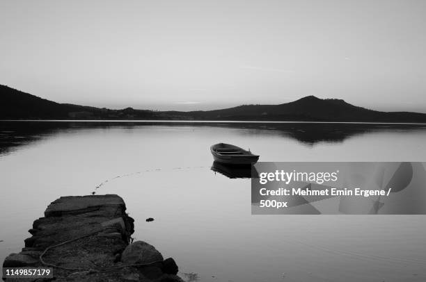 rowboat reflecting in water in black and white - rowing boat stock pictures, royalty-free photos & images