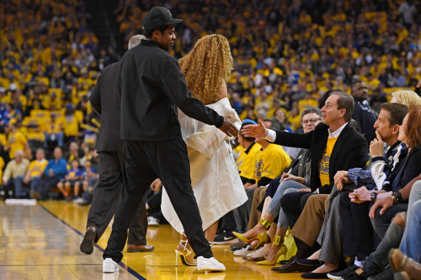 Jay-Z y Beyonce saludan al copropietario de los Golden State Warriors, Joe Lacob, durante el primer cuarto del Juego 1 de las semifinales de la Conferencia Oeste de la NBA en...